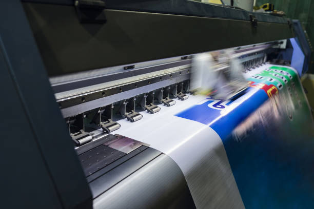 Large format inkjet printer working on vinyl paper in workplace Large format inkjet printer machine working on vinyl paper in workplace printing out stock pictures, royalty-free photos & images