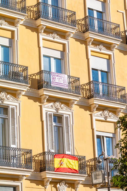 Spanish Flag on Building Exterior in Valencia, Spain. A commercial sign is visible in the background.