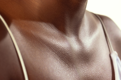 Collarbones. Detailed texture of human skin. Close up shot of young african-american female body. Skincare, bodycare, healthcare, hygiene and medicine concept. Dermatology.
