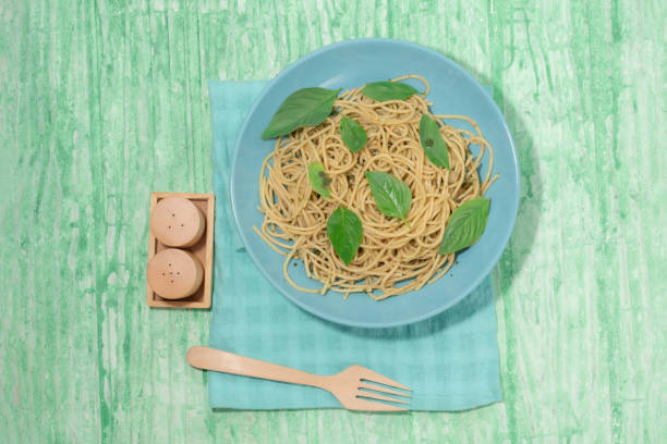 Pasta with pesto sauce in plate on green background Italian food.