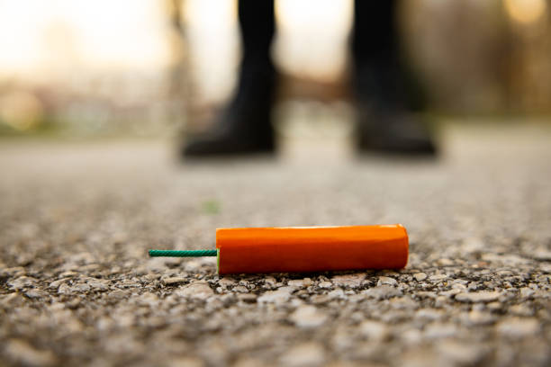 pétard orange couché dans la rue - pétard à mèche photos et images de collection