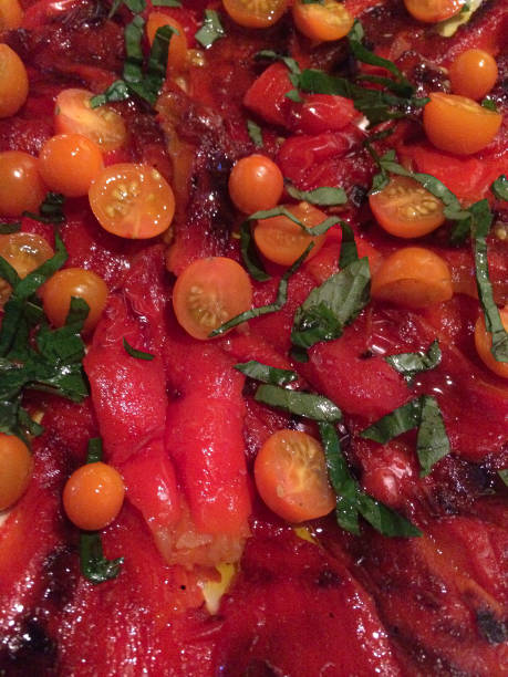 istock Platter of sliced orange cherry tomatoes on sliced red peppers 1363102472
