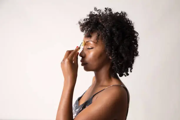 Black woman showing how to use a stone face roller