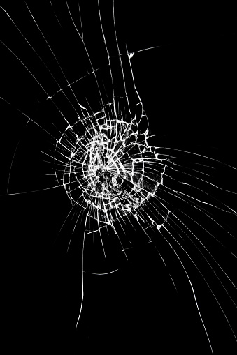 bullet hole in glass on black background