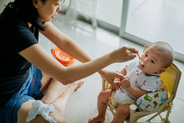 istock Mother spoon feeding rice cereal to her baby boy 1363104746