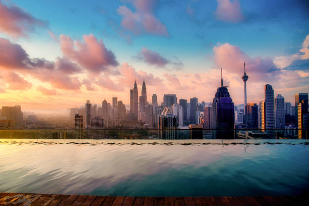 stadtbild von skyline von kuala lumpur mit swimming pool auf dem dach des hotels bei sonnenaufgang in malaysia. - malaysia stock-fotos und bilder