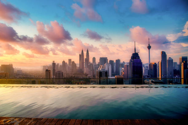 マレーシアで日の出のホテルの屋根の上にプールを持つクアラルンプール市街の街並み。 - malaysia ストックフォトと画像