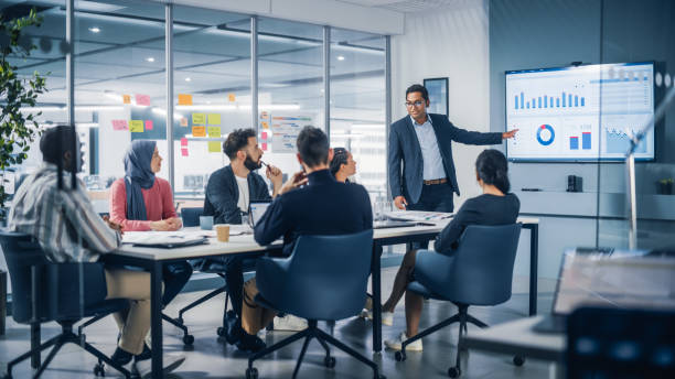 präsentation im multiethnischen bürokonferenzraum. treffen von diversen jungunternehmern, spezialisten, talking, tv für infografiken nutzen. geschäftsleute entwickeln e-commerce-startup. - indischer subkontinent stock-fotos und bilder