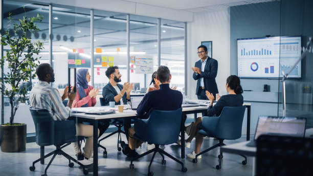 istock Multi-Ethnic Office Conference Room. Indian CEO does Presentation for Diverse Young Entrepreneurs, Talking, Using TV with Infographics, Statistics, Graphs. Businesspeople Invest in e-Commerce Startup 1363104929