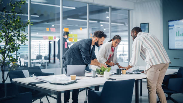 diverse team of professional businesspeople meeting in the office conference room. creative team around table, black businesswoman, african-american digital entrepreneur and hispanic ceo talking. - promotion imagens e fotografias de stock