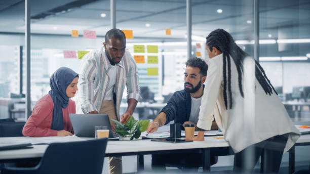istock Office Conference Room Meeting: Diverse Team of Young Investors, Workers, Developers work on Creative e-Commerce Digital Startup. Group of Multi-Ethnic Business Professionals work on Product Strategy 1363105005