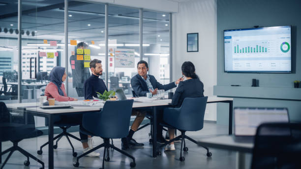 istock Multi-Ethnic Office Conference Room Meeting: Diverse Team of Successful Managers, Executives Talk, Use Green Screen Chroma Key TV. Businesspeople Investing in Growing e-Commerce Startup. 1363105009