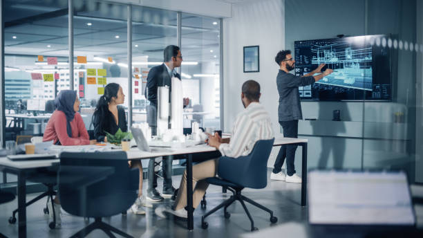 reunión de la oficina de la agencia de arquitectura multiétnica moderna. grupo de arquitectos profesionales, diseñadores, desarrolladores e inversores utilizan la televisión con el modelo de construcción 3d para diseñar un proyecto de vivienda sosten - meeting designer architect office fotografías e imágenes de stock