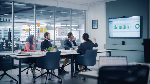 istock Multi-Ethnic Office Conference Room Meeting: Diverse Team of Successful Managers, Executives Talk, Use Green Screen Chroma Key TV. Businesspeople Investing in Growing e-Commerce Startup. 1363105080