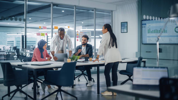 riunione della sala conferenze dell'ufficio multietnico: un team multiculturale di quattro imprenditori creativi parla, discute la strategia di crescita. diversi giovani imprenditori lavorano su digital e-commerce startup. - office worker foto e immagini stock