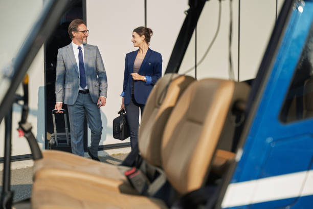 istock Two joyous people with luggage approaching chopper 1363105376
