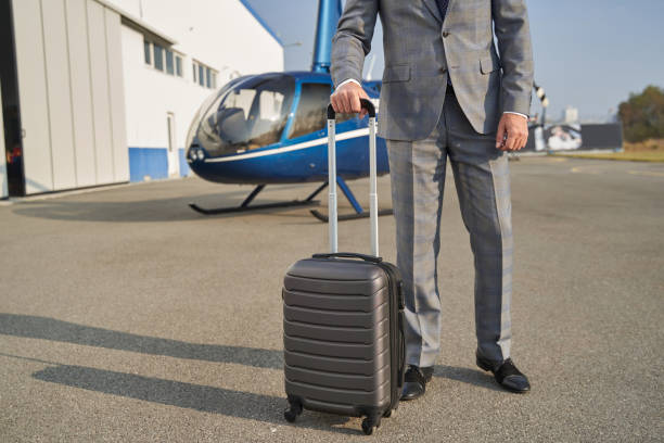 istock Elegant man with baggage standing near helicopter 1363105556
