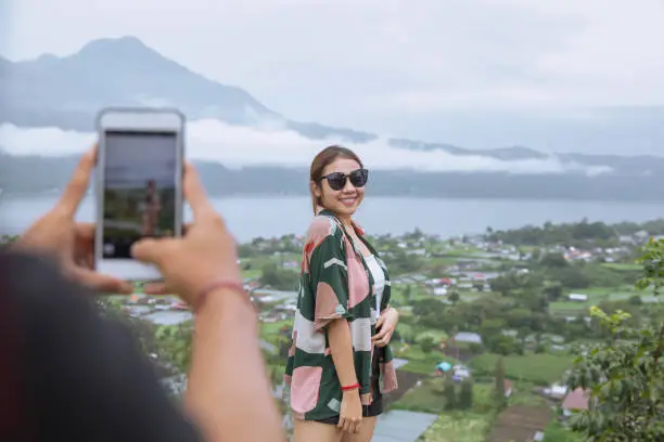 Photo of Insta Boyfriend Photographing Girlfriend with Mountain View