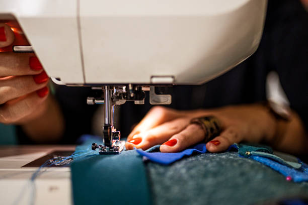 istock Dressmaker woman sews clothes on sewing machine 1363109204