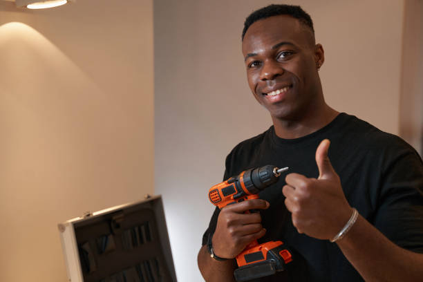 istock Multiracial man with drill showing thumbs-up to camera 1363110353