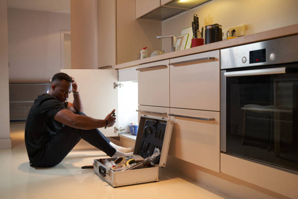 istock Man in the kitchen looking at smartphone near instrument box 1363110370