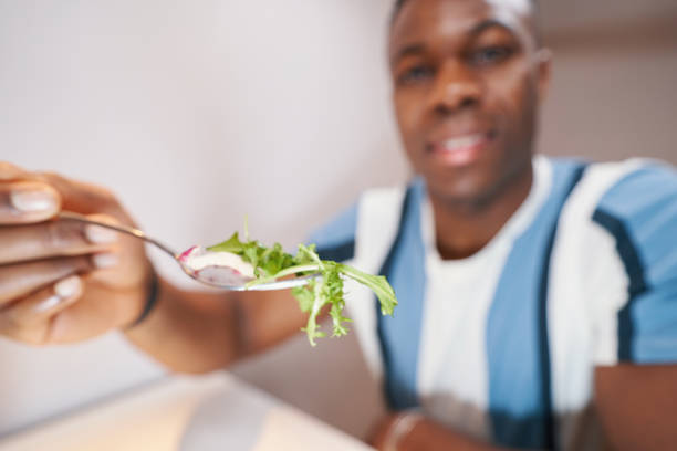 istock Male offering a piece of salad on fork 1363110414
