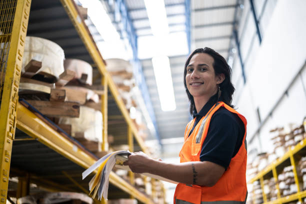 Portrait of an employee taking inventory in a factory Portrait of an employee taking inventory in a factory lgbtqcollection stock pictures, royalty-free photos & images