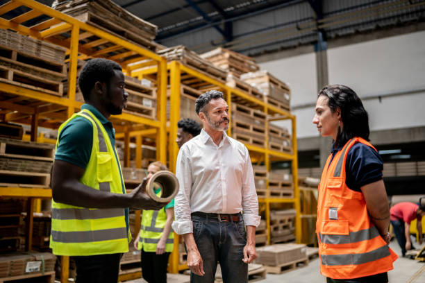 istock Team doing a meeting talking about a product in a factory - including non-binary person 1363110895