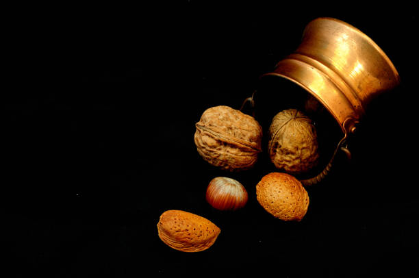 nut in copper pot on black background stock photo