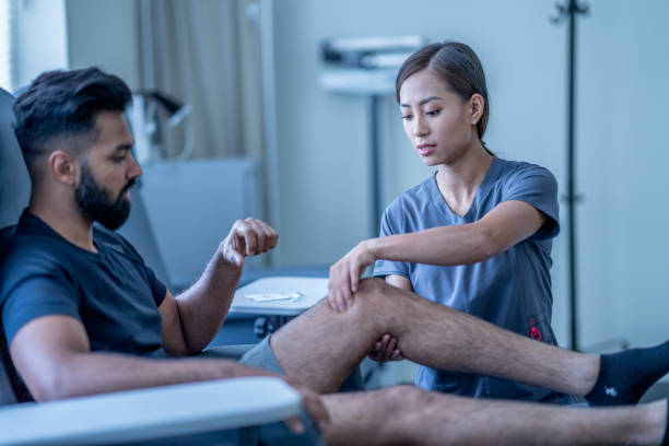 istock Physical therapist works on patient's knee 1363112313