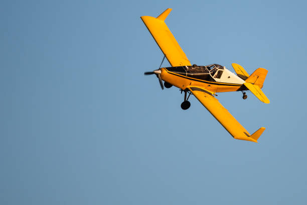 istock Yellow Crop Dusting Plane Flying in a Blue Sky 1363113204