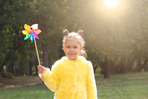 istock Beautiful child with pinwheel in park 1363120294