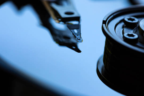 Macro Close up of inside of magnetic Hard Disc Drive with mirror surface and read writer head
