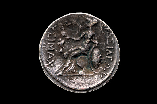 Reverse side of a Greek silver Drachum coin replica of  Alexander the Great dated from 336-323 BC cut out and isolated on a black background, stock photo image