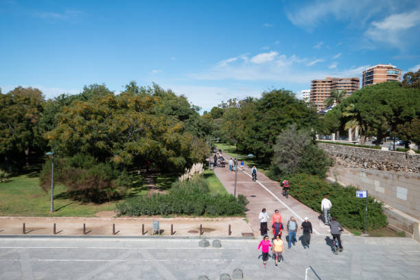 People walking  and cycling along the Turia Riverbed Gardens in Valencia, Spain