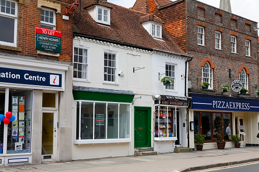 Chichester, England, UK - June 6, 2010: shop windows in traditional buildings on the ground floor with direct access from the sidewalk on one of the streets in this town