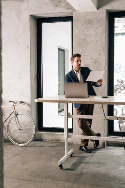 istock Businessman in a Suit Working at a Standing Desk 1363123397