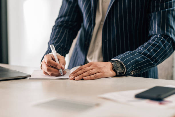 istock Anonymous Businessman in a Suit Working at a Standing Desk 1363123406