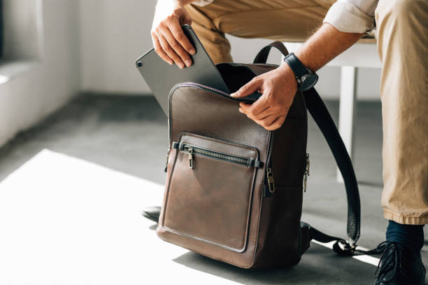 anonymer lehrer packt seinen lederrucksack in der bibliothek - leader of the pack stock-fotos und bilder