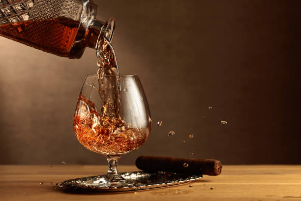 cognac und zigarre auf einem eichentisch. - wine decanter elegance pouring stock-fotos und bilder