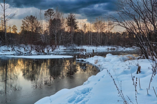 istock Winter landscape forest river with a bridge in the background at sunset. 1363127312