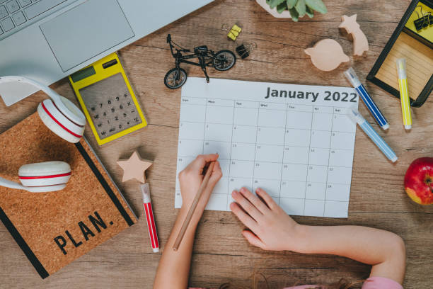 istock Top view of kids hands using calendar for planning 1363129490