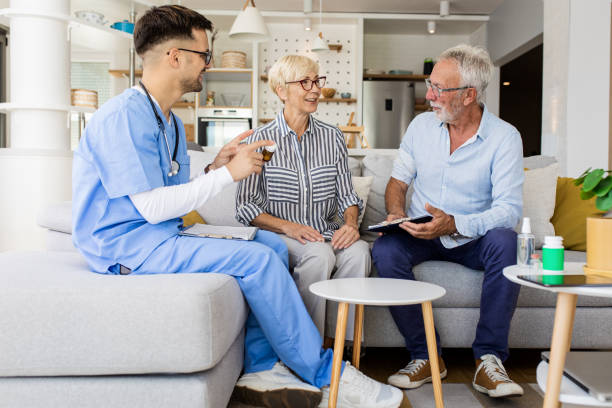 istock Male nurse talking to seniors patients while being in a home visit. 1363129507