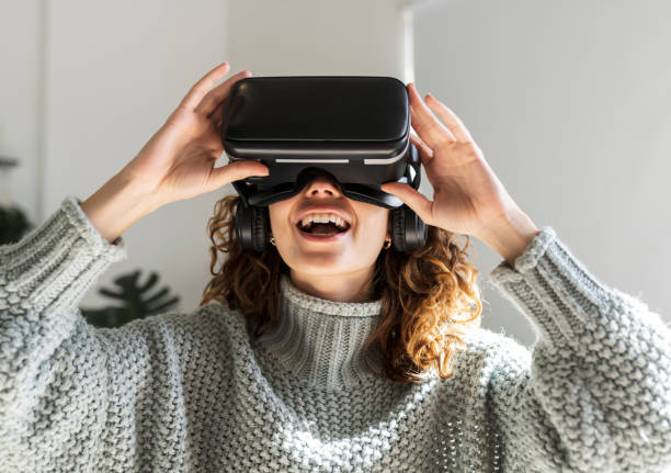 mujer hispana de pelo rizado, sorprendida mientras veía una película con gafas de realidad virtual - vertical caucasian glasses red hair fotografías e imágenes de stock