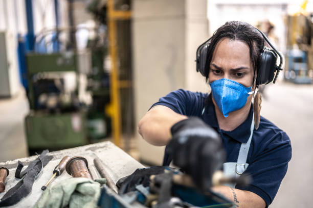 istock Non-binary person working at a factory/industry - using a face mask 1363134716