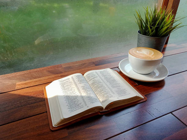 bíblia sobre mesa de madeira com luz matinal através da janela de vapor no inverno. conceito amor estudar palavra de deus na hora do café, cristão acredita santa cruz,fé,esperança,perdão, oração adoração chave para o novo dia. - believe miracle church forgiveness - fotografias e filmes do acervo