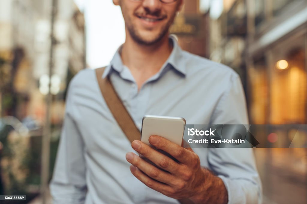 Young man in the city Online Booking Stock Photo