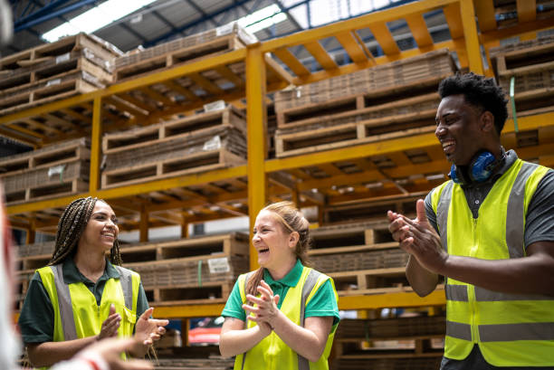 mitarbeiter applaudieren während des meetings in einer fabrik - warehouse worker stock-fotos und bilder