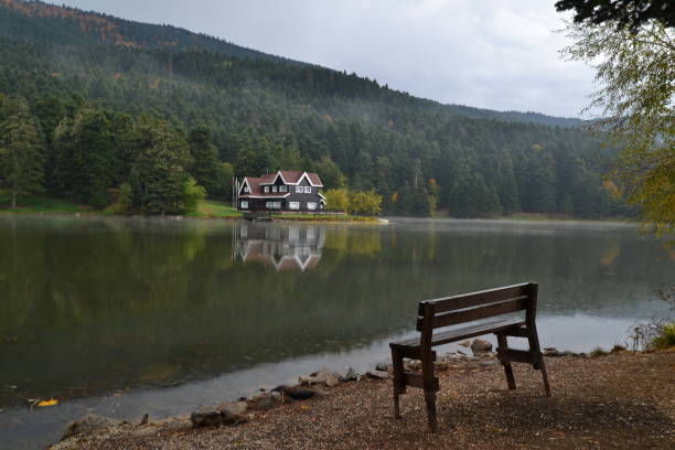 Famous Photography spot in Turkey called Golcuk lake. A wooden cottage and a bench composition with lake, reflection on water, during morning time. Beautiful landscape Turkey photo, Golcuk, TUrkey, October 2012.