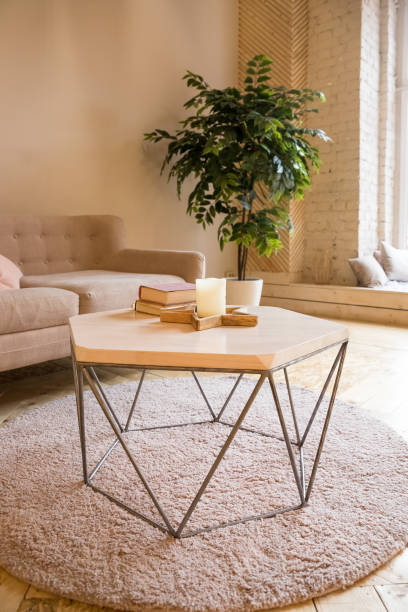 istock Room in a loft style. Room interior with sofa,small table and little tree. There is a sofa with small table with a books and candles on it,home plants . On the floor there is a parquet and carpet. 1363143050